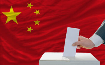 man putting ballot in a box during elections in china