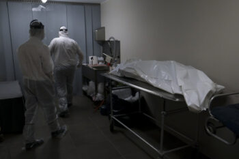 Mortuary workers put the body of a victim of the coronavirus disease (COVID-19) inside a coffin at the Fontaine funeral home during a partial lockdown to prevent the spread of coronavirus in Charleroi, Belgium, on April 9 , 2020.