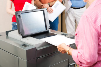Closeup of a senior woman casting her ballot on a new electronic voting machine.