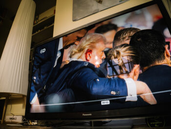 London, UK - Jul 14, 2024: Living rooom TV Breaking live images of an attempted assassination show Donald Trump, a US presidential candidate, with blood on his ear and a defiant stance