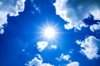 Blue sky with clouds and sun.